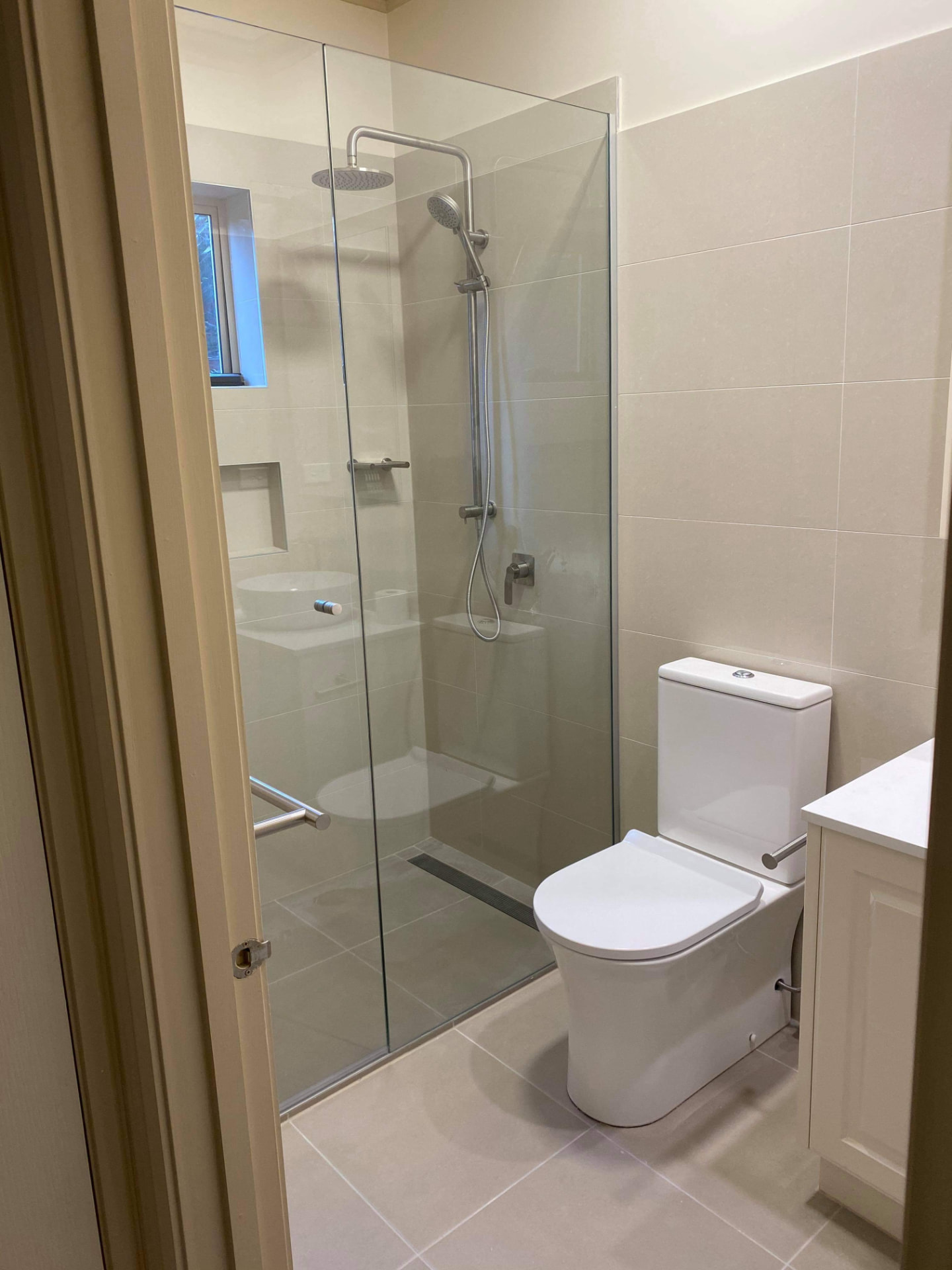 Completed bathroom with frameless glass shower